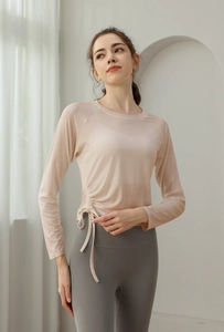 Detail of adjustable side drawstring and ruched texture on long sleeve yoga top