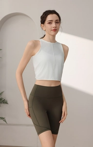 Detailansicht der weißen Yoga-Weste und der olivgrünen Radlerhose mit hoher Taille