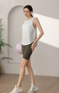 Détail du débardeur de yoga blanc ample avec fente latérale et short de cyclisme olive