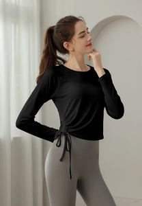 Detail of slim fit black yoga top featuring side drawstring and ruched waist design