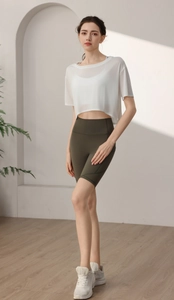 Close-up of white translucent sports tee with olive green high waist cycling shorts