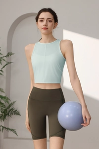 Detail von hellblauem Yoga Crop Top und olivgrüner High Waist Shorts an einem Frauenmodell