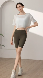 Detail of white semi-transparent yoga cover-up with olive green high waist cycling shorts