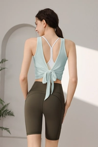 Detail der Yoga-Tanktop mit Kreuzrücken, Schleifensaum und olivgrünen Radlerhosen