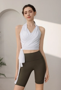 Dettaglio del top da yoga slim con fiocco laterale e pantaloncini fitness verde oliva a vita alta