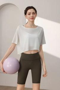 Close-up of white semi-transparent yoga top with high-waist olive cycling shorts