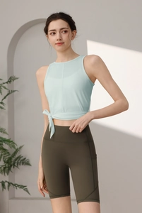 Detail von hellblauem Yoga-Top mit Seitenknoten und olivgrüner High-Waist-Shorts