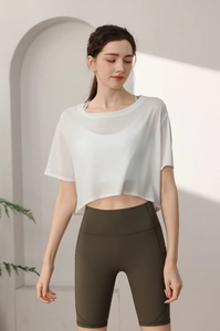 Detail of white mesh t-shirt over sports bra and olive green high waist yoga shorts