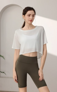 Detail of white mesh yoga top and high-waisted olive green fitness shorts for women