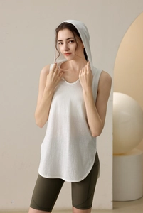 Loose white hooded gym vest for women with curved hem paired with green biker shorts