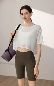 Detail view of white translucent mesh yoga cover-up and olive green high-waisted shorts