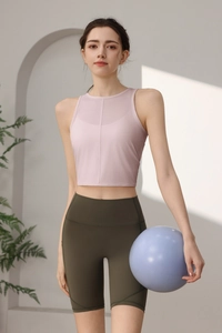 Detail des rosa Yoga-Tanktops und der olivgrünen Fitness-Shorts mit hoher Taille
