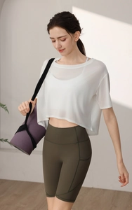 Detail of white mesh yoga cover-up and olive green high-waisted cycling shorts