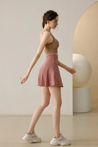 Détail de la jupe de tennis plissée rose poudré avec taille haute et poche
