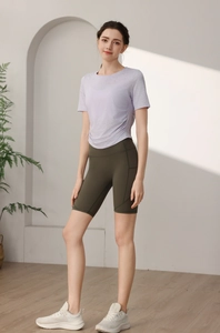 Détail d'un t-shirt de yoga lavande avec fronces et d'un short cycliste olive