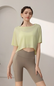 Detail view of mesh crop top and high-waisted yoga shorts with side pockets and cross waist
