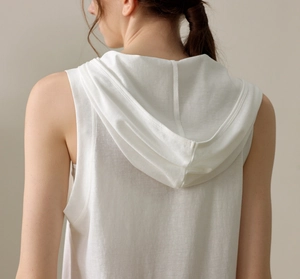 Detail of loose-fit white hooded yoga tank top showing breathable mesh fabric on model back