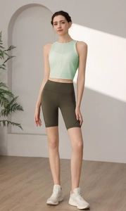 Detail von hellgrünem Yoga-Tanktop und olivgrüner Radlerhose mit Seitentasche