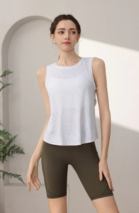 Dettaglio del gilet da yoga jacquard bianco e pantaloncini a vita alta verdi su modella