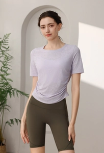 Détail du t-shirt de sport lilas respirant et du short de fitness vert taille haute