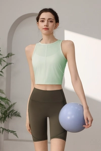 Detailansicht des hellgrünen ärmellosen Yoga-Tops und der olivgrünen High-Waist-Radlerhose