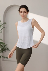 Dettaglio della canotta da yoga in mesh bianco e pantaloncini sportivi verdi su modella