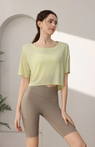 Detail view of a pale green loose yoga top and high-waisted shorts with side pocket