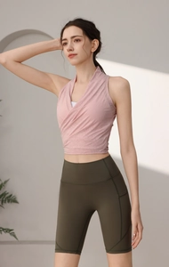 Dettaglio del reggiseno yoga rosa con scollo all'americana e pantaloncini biker verdi a vita alta