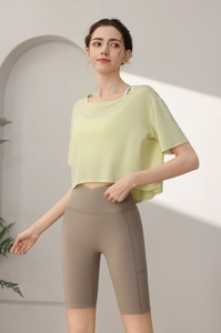 Lime green loose fit gym top with taupe high waist biker shorts featuring side pockets
