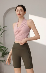 Dettaglio del gilet sportivo allacciato al collo rosa e pantaloncini yoga a vita alta