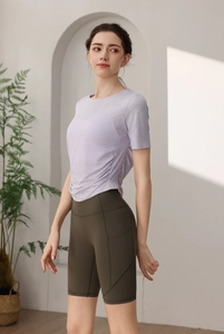 Vue détaillée du haut de yoga violet avec cordon et legging vert olive avec poches
