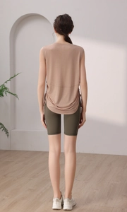 Detail view of a loose taupe athletic tank top with adjustable side drawstring and shorts