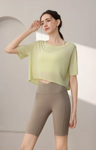 Detail of light yellow mesh sports cover-up with V-cross waist yoga shorts and side pockets