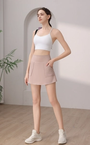 Dettaglio della gonna pantalone da yoga rosa a vita alta con tasca laterale e top bianco
