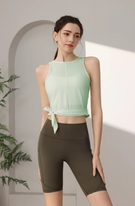 Detail eines minzgrünen Yoga-Oberteils mit seitlichem Knoten und olivfarbener Radlerhose