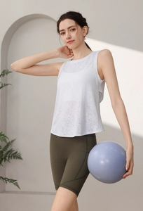 Dettaglio della canotta da yoga in mesh bianca e dei pantaloncini biker a vita alta oliva