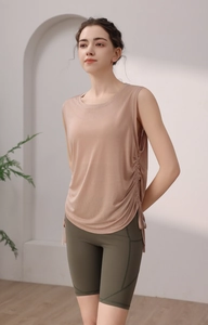 Detail of apricot yoga tank top with side drawstring ruching and olive green bike shorts