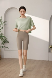 Detail of loose tencel cropped sports top and high waist v-cross biker shorts for gym