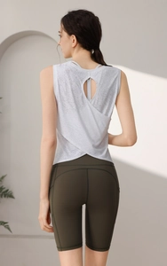 Dettaglio del design incrociato sulla schiena del top da yoga bianco e pantaloncini