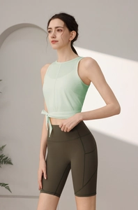Detail der Kreuzschnürung und Seitentaschen an Yogatop und olivfarbenen Shorts