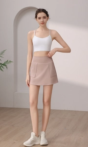 Dettaglio del reggiseno sportivo bianco e minigonna atletica rosa cipria con tasca