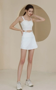 Détail d'un ensemble jupe de tennis blanche taille haute avec oeillets métalliques