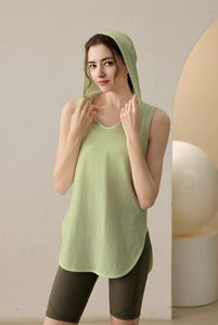 Detail of light green hooded sleeveless fitness top with curved hem and quick-dry fabric