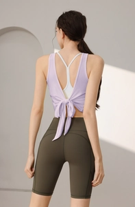 Detail von lavendelfarbenem rückenfreiem Yoga-Top mit Schleife und olivfarbenen Shorts