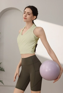 Dettaglio del gilet da yoga incrociato verde chiaro con pantaloncini da ciclista oliva