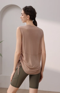 Detail view of the drawstring ruched side and curved hem on a women's yoga tank top