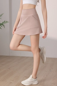 Dettaglio della gonna pantalone sportiva rosa pallido a vita alta con tasche laterali per tennis