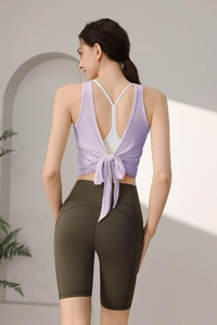 Detail von lavendelfarbenem Yoga-Top mit offenem Rücken, Schleife und olivgrüner Hose