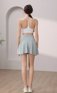 Dettaglio del retro del reggiseno sportivo bianco e della gonna da tennis a pieghe