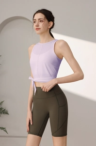 Detail von lavendelfarbenem Yoga-Top mit Seitenschleife und grüner High-Waist-Radlerhose